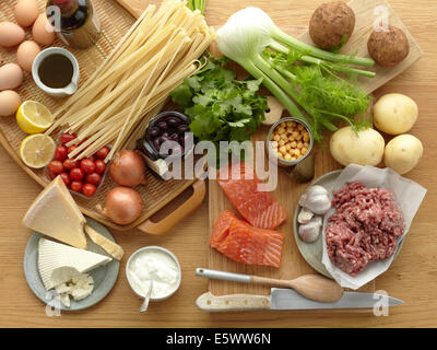 Selection of fresh raw foods with eggs, pasta, herbs, cheese, vegetables, salmon and minced pork Stock Photo