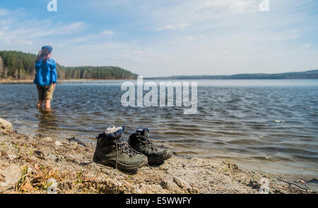 Mid adult female hiker taking a paddle in lake Stock Photo