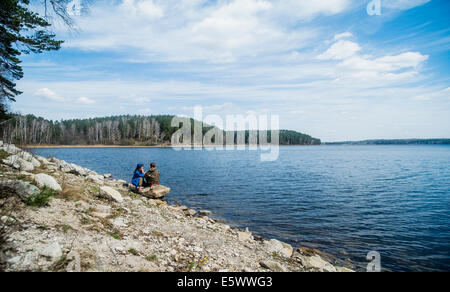 Two female hiking friends taking a break on lakeside