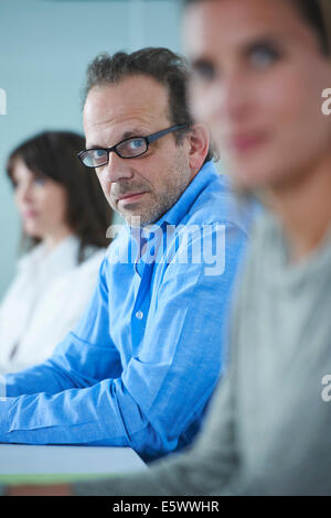 Portrait of businessman in row of colleagues Stock Photo