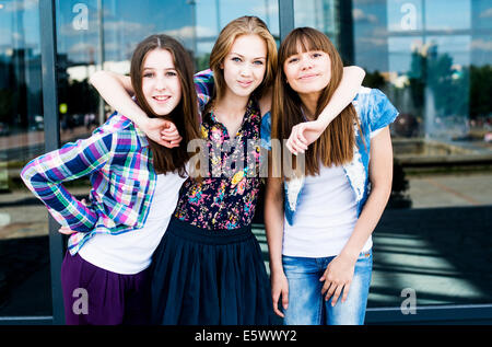 Portrait of three smiling young women in city Stock Photo
