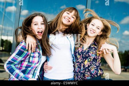 Three young women shaking hair in a row Stock Photo