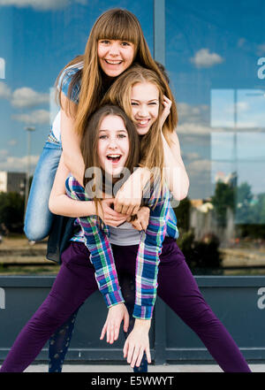 Three young women stacked on top of each other in city Stock Photo