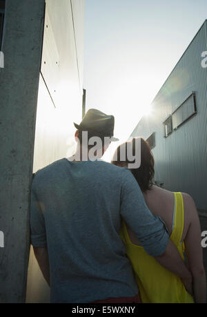 Rear view of young couple in street Stock Photo