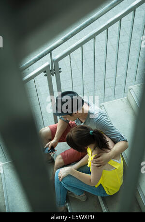 High angle view of young couple sitting on stairway Stock Photo