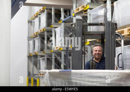 Senior man using forklift truck in factory Stock Photo