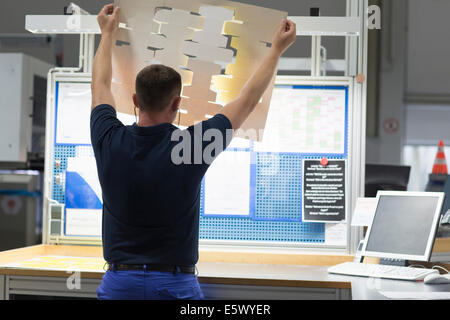 Worker looking at product in paper packaging factory Stock Photo