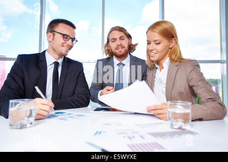 Group of business partners discussing papers at meeting in office Stock Photo