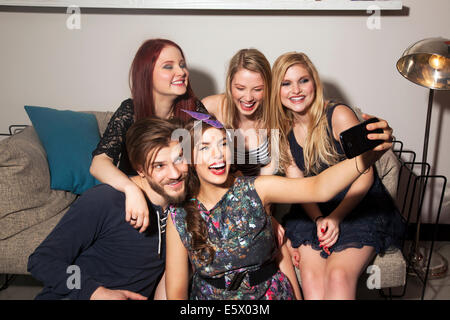 Friends taking selfie on sofa