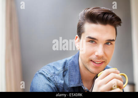 Portrait of young man drinking coffee Stock Photo