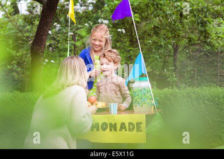 Mother buying lemonade from daughter's stand Stock Photo