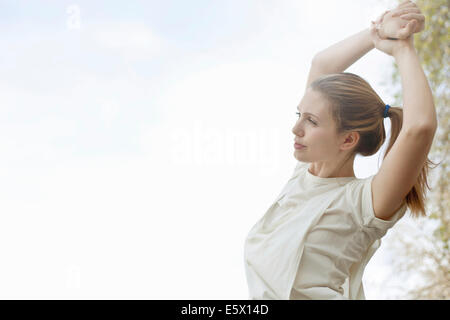 Young woman stretching arms before exercise