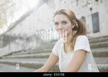 Portrait of young woman on steps Stock Photo