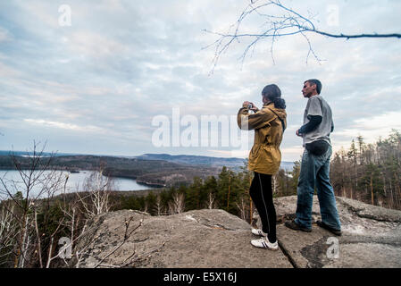 Young couple on top of rock formation photographing view Stock Photo