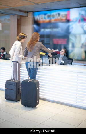 Two businesswoman checking in at conference centre Stock Photo