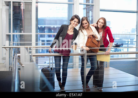 Three businesswomen watching from balcony in conference centre Stock Photo