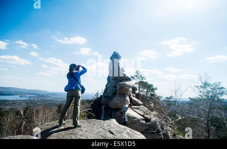 Two hikers on top of rock formation taking photographs Stock Photo