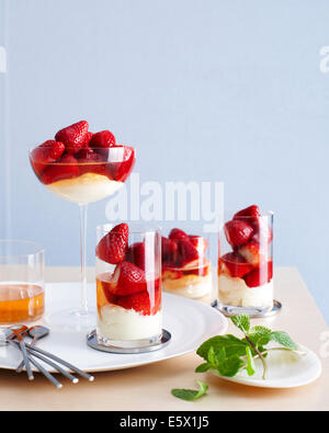 Selection of drinking glasses filled with champagne poached strawberry desserts Stock Photo