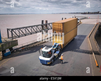 Elevated view of truck and shipping container on ramp to ship