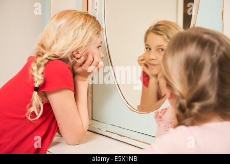Girl staring at sister in bedroom mirror Stock Photo