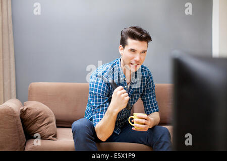 Young man watching TV in living room Stock Photo