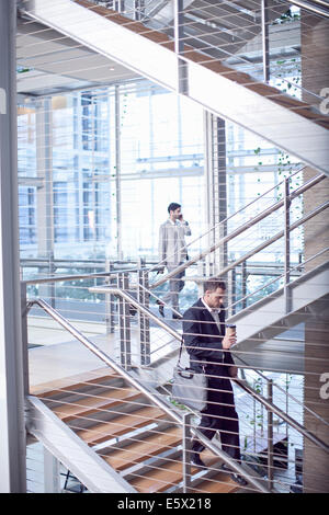 Two young businessmen on conference centre stairway Stock Photo