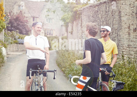 Cyclists stopping by stone wall, Cotswolds, UK Stock Photo