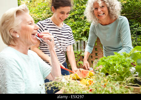 Three women preparing food at garden table Stock Photo