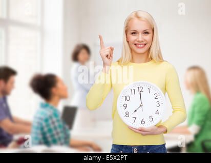 student with wall clock and finger up Stock Photo
