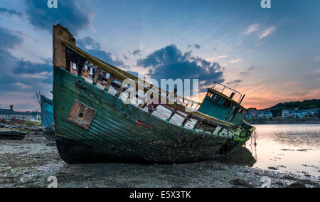 Decaying old boat wreck abandoned on the shore of Hooe Lake in Plymouth, Devon Stock Photo