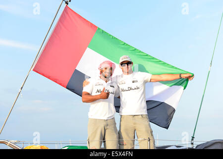 Isle of Wight, UK. 6th Aug, 2014. Abu Dhabi, makes debut at Cowes, naming of Azzam, Abu Dhabi Ocean Racing's contender of the new generation of boat, V065 for the 2014/15 Volvo Ocean Race.The boats will arrive in Abu Dhabi on 14-15 December following their leg from Cape Town. Members of the team including Ian Walker (Skipper) right Adil Khalid ( (Trimmer and helmsman- under 30) left.The name Azzam means 'determination.'This was followed by races in a prize-winning day with the team on Azzam in the Artemis Challenge on a race around the Isle of Wight. Credit:  Gary Blake/Alamy Live News Stock Photo