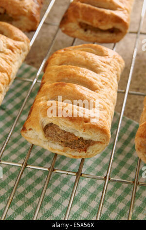 Freshly baked pork sausage rolls cooling on a rack Stock Photo