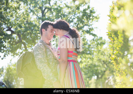 Male soldier holding hands with wife on street at homecoming Stock Photo