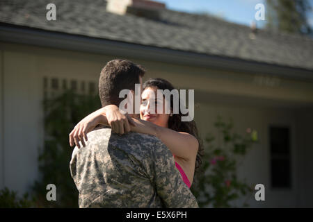 Male soldier hugging wife in garden on homecoming Stock Photo