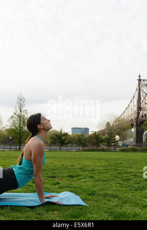 Young woman practicing yoga in city park