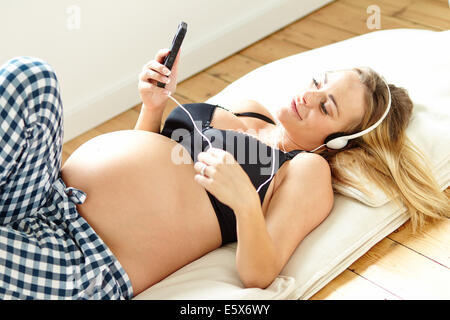 Pregnant relaxing listening to music Stock Photo