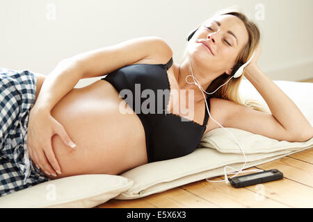 Pregnant relaxing listening to music Stock Photo