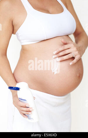 Pregnant woman moisturising Stock Photo