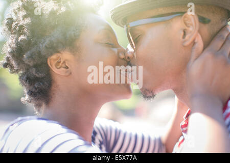 Close up of young couple kissing in park Stock Photo