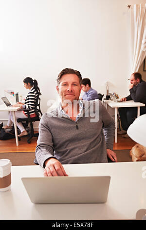 Portrait of man in office with laptop Stock Photo
