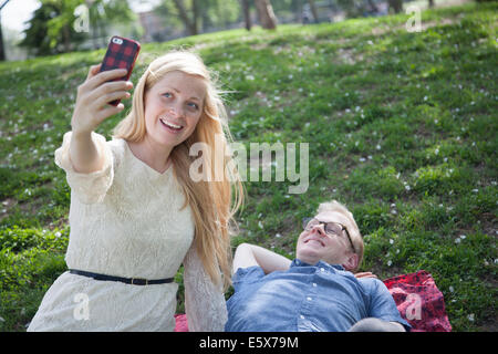 Young couple taking selfie with smartphone in park Stock Photo