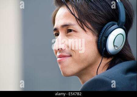 Close up of mid adult businessman listening to music on headphones Stock Photo