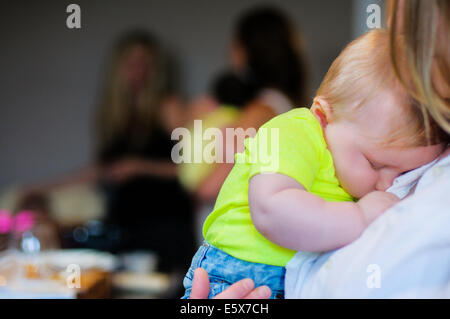 Close up of baby boy asleep on mother's shoulder Stock Photo