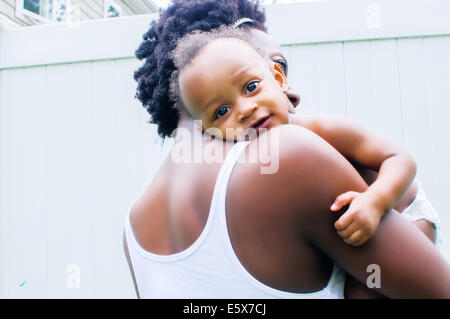 Portrait of baby boy looking over mother's shoulder Stock Photo