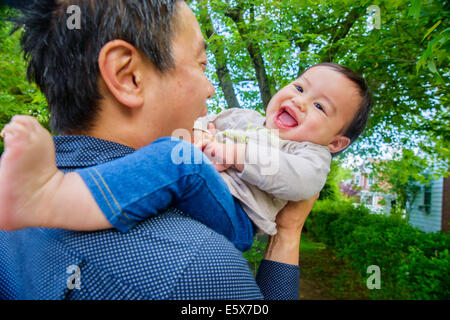 Mid adult father playing with baby son in garden Stock Photo