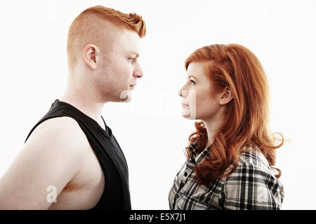 Studio portrait of red haired young couple gazing face to face Stock Photo