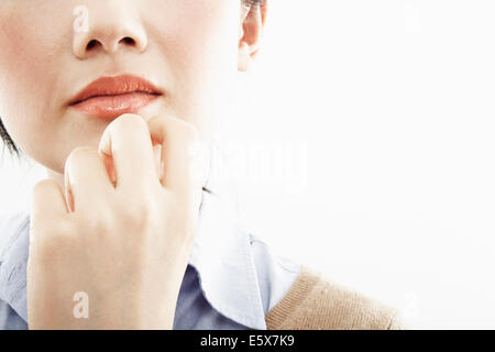 Cropped close up of hand on young woman's chin Stock Photo