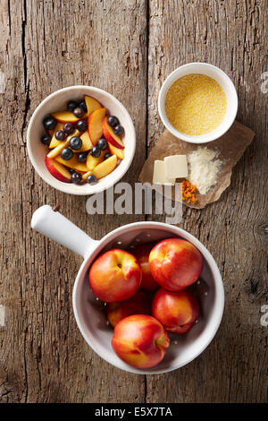Fresh blueberries and nectarines with dry polenta, butter, orange zest and organic flour Stock Photo