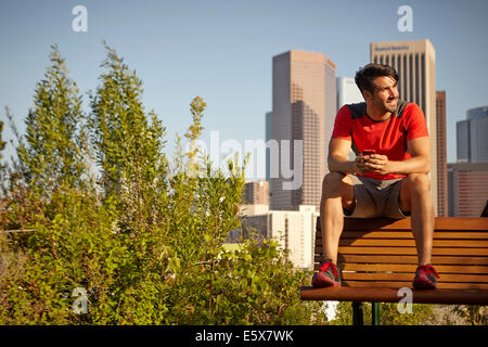 Young male runner taking a break on park bench Stock Photo