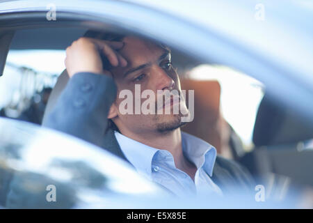 Mid adult businessman driving in traffic congestion Stock Photo